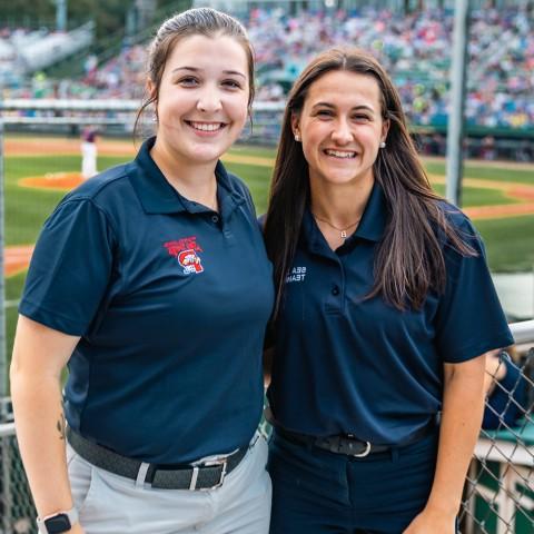 Two UNE 业务 students pose in front of the baseball diamond at Portl和's Hadlock Field